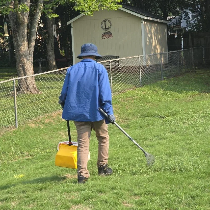 Kumo Pest Control technician providing dog waste removal service in a residential yard